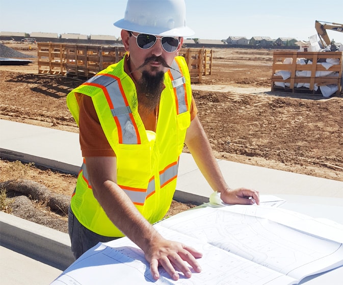 Jordan Horn, Lead Consultant — reviewing blueprints at job site